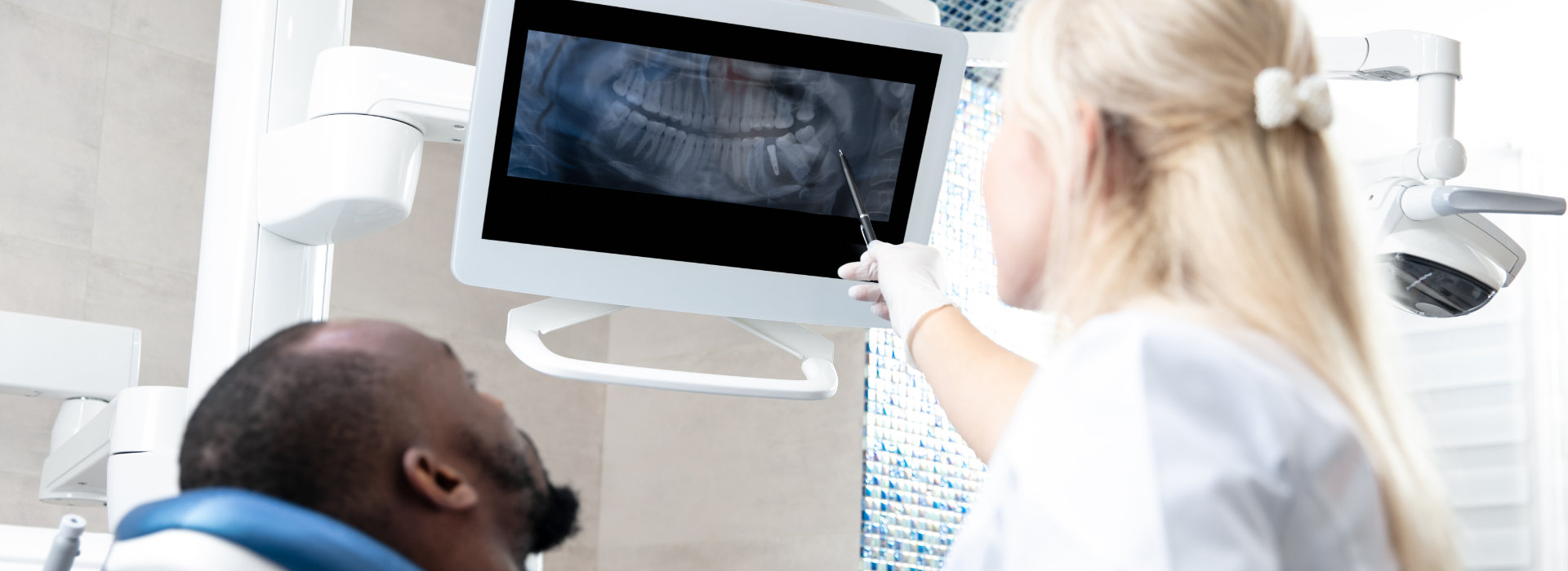 The dentist is showing the dental x-ray results to the patient.