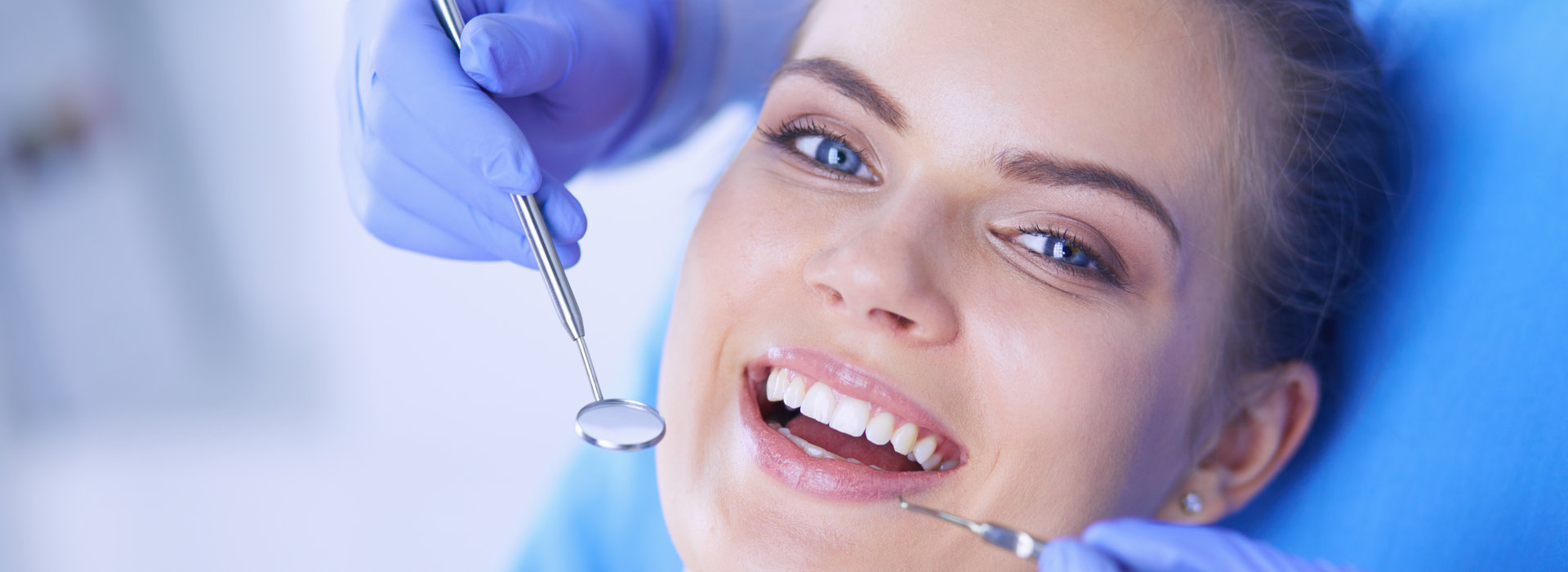 A woman is smiling after receiving porcelain veneers treatment.