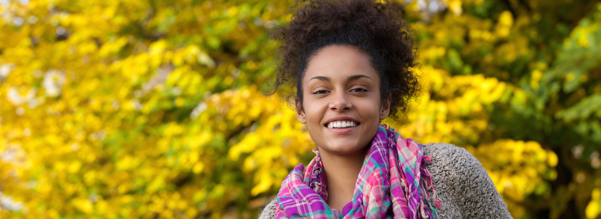 A woman is smiling after receiving cosmetic dentistry.