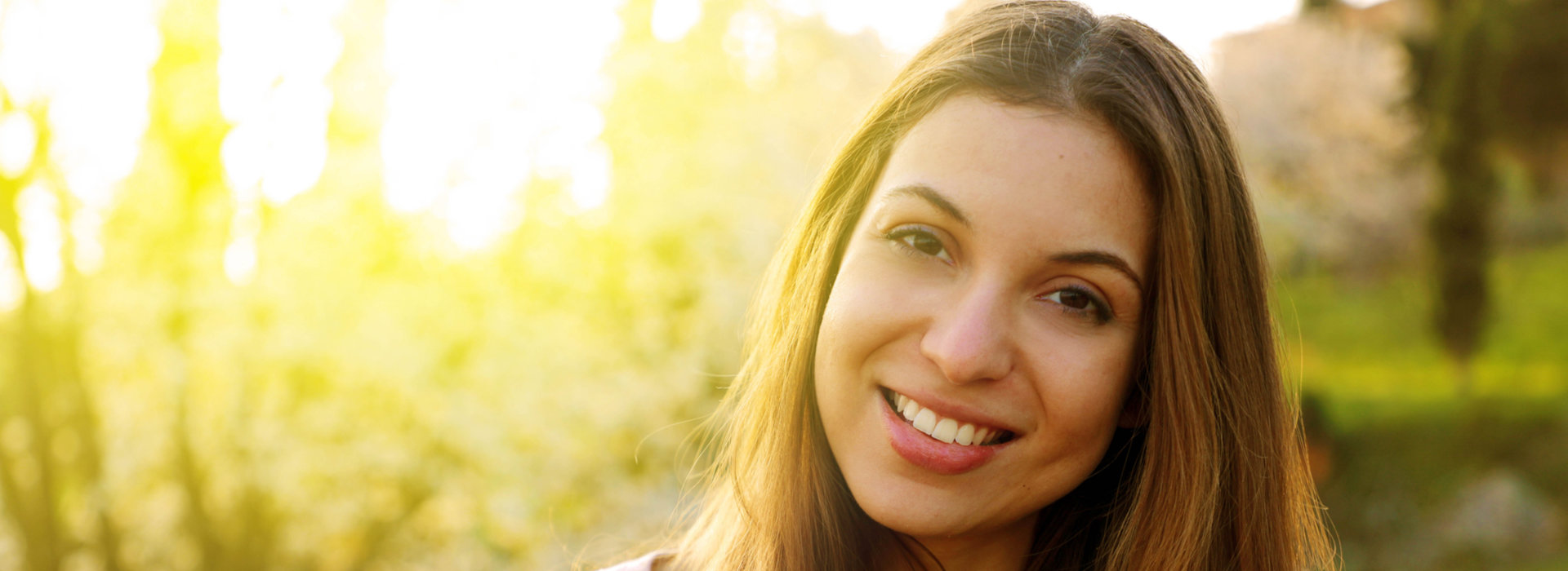 A woman is smiling after receiving treatment for teeth grinding.