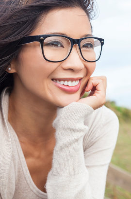 A woman is smiling after teeth implants.